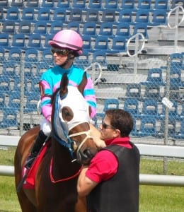 Assistant starter Chris Campitelli leads a horse into the gate.  Photo by Teresa Genaro.