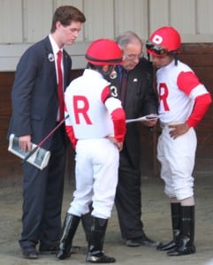 Ken Ramsey, center, and his grandson Nolan go over race strategy with riders Joel Rosario and Shaun Bridgmohan before the Virginia Derby.  Photo by Nick Hahn.