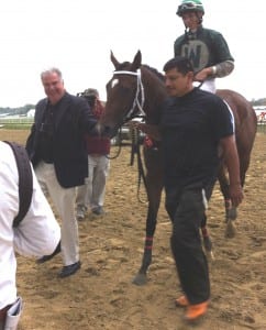 A triumphant David Wimer (left) helps lead Selima Stakes winner Aibhilin into the winner's circle.