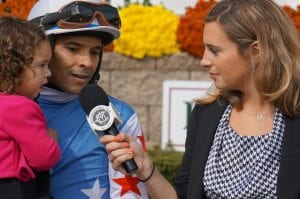 Richard Monterrey holds daughter Daniella while talking with Gabby Gaudet after winning the Maryland Million Nursery aboard It's a Bang.