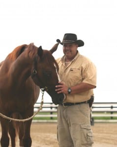 Kerry Thomas visits with a horse.  Photo courtesy of Thomas Herding Technique.