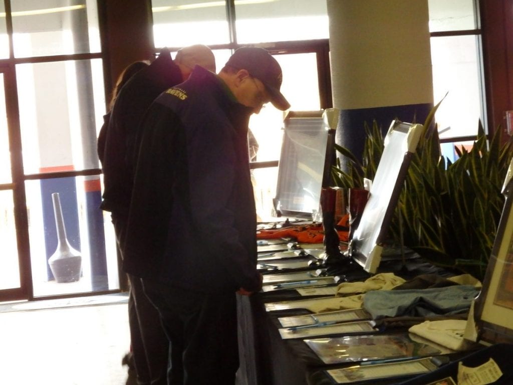 Racing fans look over some of the auction items during the Fundraiser for Fray. Photo by The Racing Biz.